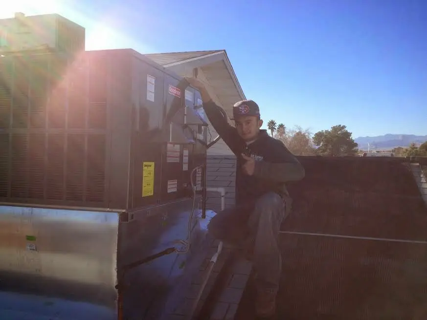 HVAC technician performing AC Tune-Up on a rooftop unit in Beekman